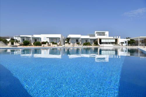 安倍拉斯Ambelas Mare Apartments的一个大型蓝色游泳池,其建筑背景为: