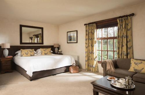 布什米尔斯布什米尔斯酒店和餐厅的一间卧室配有一张床、一张沙发和一个窗口