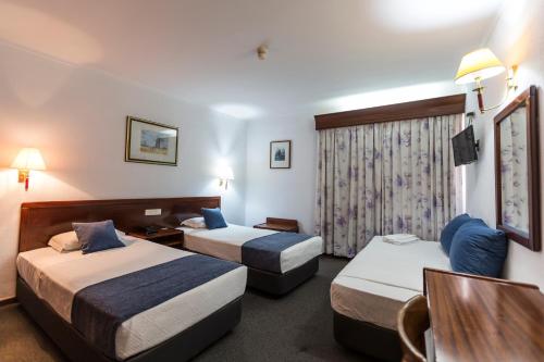 塞图巴尔阿兰格斯酒店的一间酒店客房,设有两张床和电视