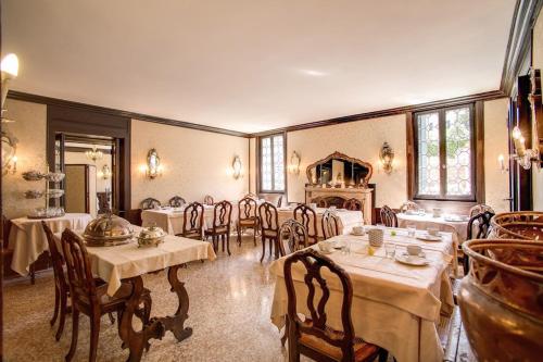 威尼斯佩希恩赛古索酒店的大型用餐室配有桌椅