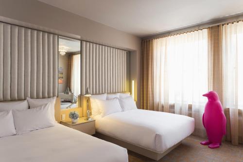 达拉姆达勒姆21C博物馆酒店的酒店客房设有两张床和大窗户。