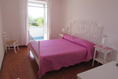 伊斯基亚Casa Antonio的一间卧室配有一张带粉色毯子的大床