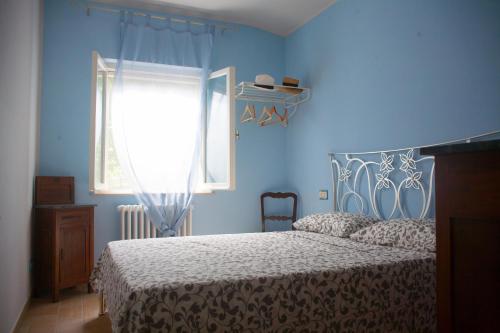 MonterubbianoCasa vacanze a Rubbianello的蓝色的卧室设有床和窗户