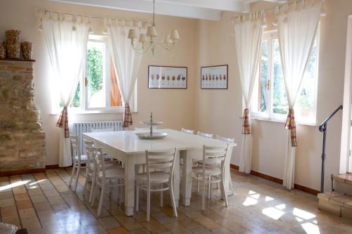 MonterubbianoCasa vacanze a Rubbianello的一间配备有白色桌椅的用餐室