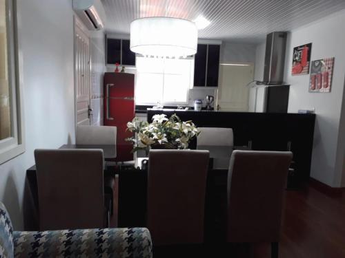 格拉玛多Glamour Gramado Residence的餐桌、椅子和花瓶