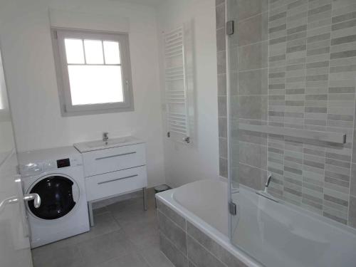 安德诺莱斯贝恩Villa du Cabestan的白色的浴室设有洗衣机和浴缸。