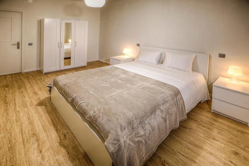 波尔图Aromas Flavors Tours - Apartment Velasquez的一间卧室设有一张大床和两个床头柜