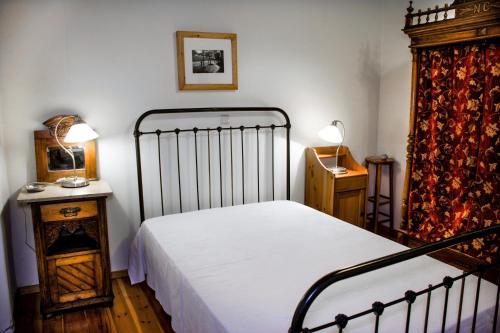 TselendátaNostos Residence - Apartment Terra的一间卧室配有一张床、一张桌子和两盏灯。