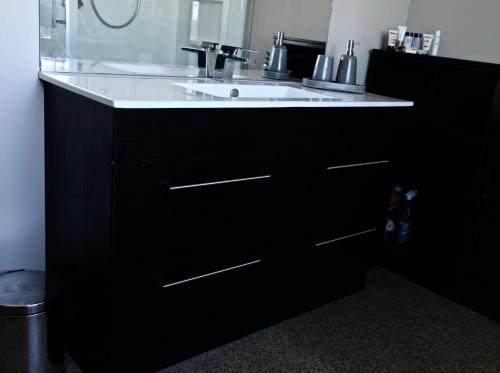 马塔卡纳Kahu Farm Apartment的浴室配有白色水槽和黑色橱柜。