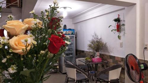 顺化谭宏民宿的一间房间,配有一张桌子和一束鲜花