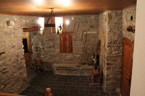 Forcat图里斯莫卡萨萨斯特雷乡村民宿的一间设有石墙的房间,里面装有吉他