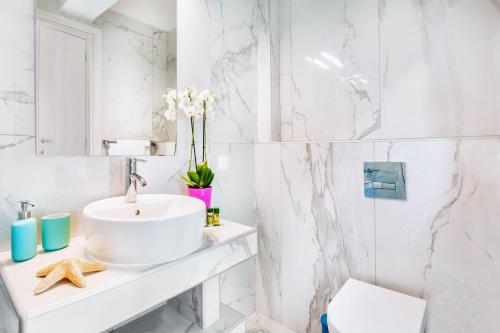 佩科霍里Asterias Premium Holiday Apartments的白色的浴室设有水槽和卫生间。
