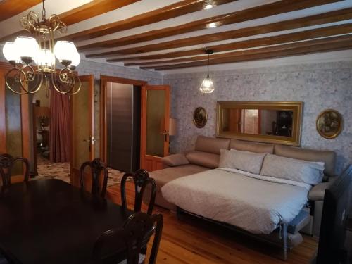 拉瓜迪亚Alojamiento Santa Engracia Laguardia的客厅配有床和餐桌