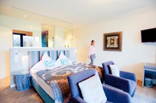 Bardenhagen古特巴德哈根酒店的一间卧室配有一张床和两张蓝色椅子