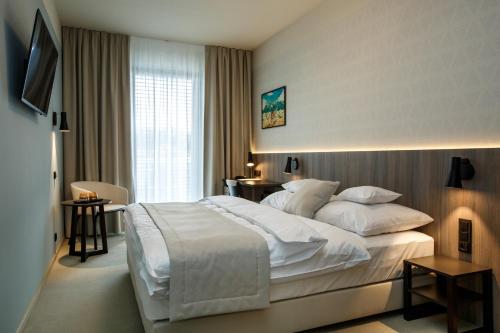 瓦拉什斯凯梅济日奇Hotel Rajka的酒店客房配有一张带白色床单和枕头的大床。