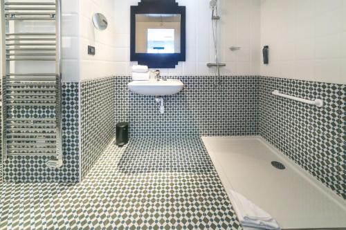 圣罗兰度瓦Best Western Hôtel Journel Saint-Laurent-du-Var的浴室配有盥洗盆和浴缸。