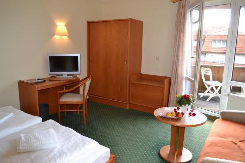 科尔平塞加尼瑟斯霍斯恩酒店的酒店客房配有一张床和一张书桌及一台电视