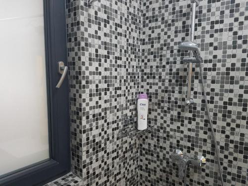 北马马亚-讷沃达里Holiday Apartment Mamaia Nord的浴室铺有黑白瓷砖,设有淋浴。