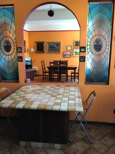 莱萨Rainbow Relais的一间设有桌子和彩色玻璃窗的客房