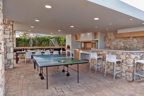 普拉坦斯Villa Green Diamond - Private Heated Pool的天井设有乒乓球桌和酒吧。