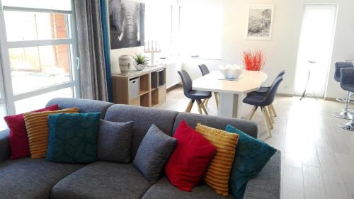 LiersAppart HautsSarts的客厅配有蓝色沙发及色彩缤纷的枕头