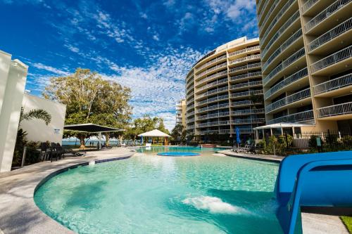 卡伦德拉双子座度假酒店的一座大建筑前的游泳池