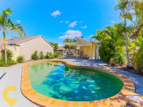 黄金海岸Gold Coast Theme Park Family Villa的房屋前的大型游泳池