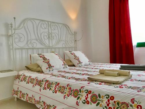 卡门港弗莱博艳公寓（仅限成人）的一间卧室配有一张带红色窗帘的床