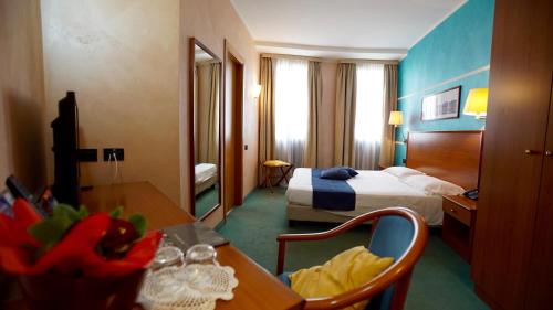 特尔尼郁金香经典酒店的配有一张床、一张桌子和一张桌子的酒店客房