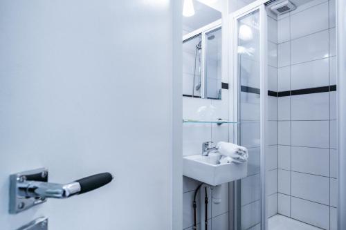 阿姆斯特丹帕特里克斯普雷斯住宿加早餐旅馆的白色的浴室设有水槽和淋浴。