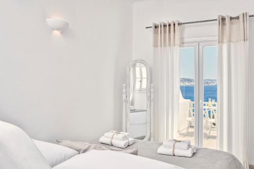 圣斯特凡诺斯Mykonos Princess Hotel的白色的客房配有一张床,享有海景