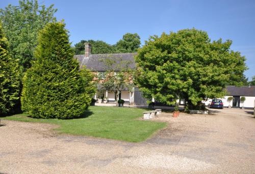 沙夫茨伯里Stable Cottage, Whitebridge Farm的前面有树和长凳的房子