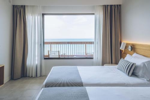 帕尔马海滩AYA Seahotel - Adults Only的一间卧室设有一张床和一个大窗户