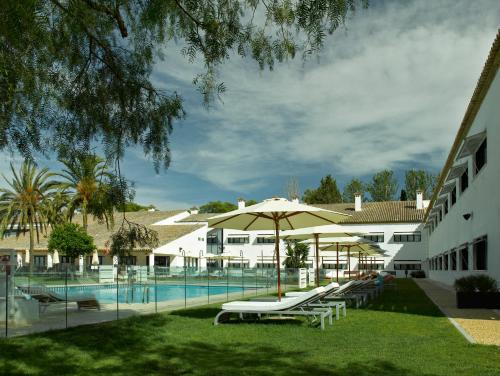 安特克拉安特奎拉旅馆的一个带游泳池、椅子和遮阳伞的度假村