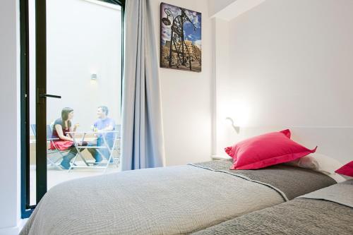 巴塞罗那生活梦想酒店的一间卧室配有一张带红色枕头的床和一个阳台