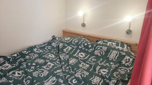 科莱恩斯普拉特studio-appartement in paardenstal的一张带绿色和白色棉被和枕头的床
