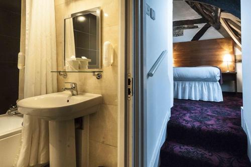 图克斯伯里霍普波勒沃德斯庞皇家酒店的一间带水槽的浴室和一间带床的房间