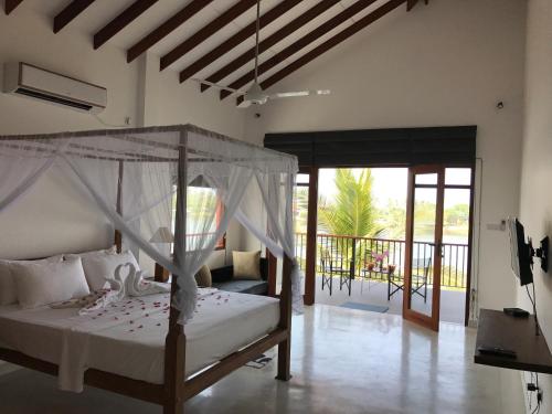阿鲁特伽马Malu Banna的一间卧室设有一张天蓬床和一个阳台