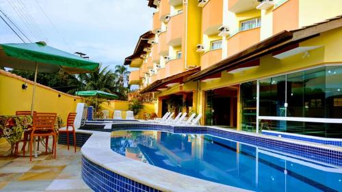 圣劳伦斯海滨Hotel Canto da Riviera的一座游泳池,位于酒店大楼旁边