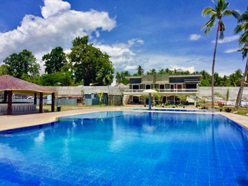 GitagunLagoon beach resort的一座蓝色的大型游泳池,其建筑背景为: