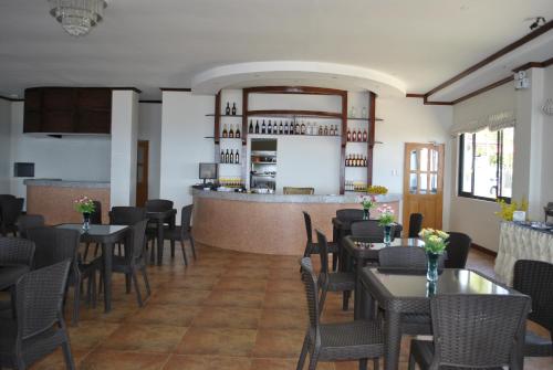 GitagunLagoon beach resort的一间带桌椅的餐厅和一间酒吧