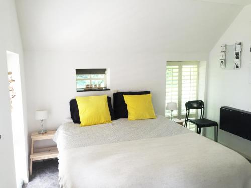 RuinenB&B De Achterdiek的一间卧室配有一张带黄色枕头的大床