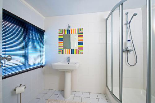 戈德尔明Godalming Hotel Guest House的白色的浴室设有水槽和淋浴。