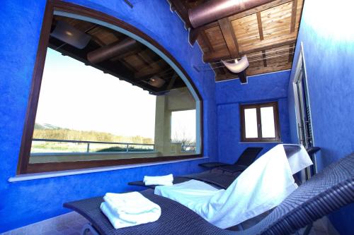 拉奎拉迪莫拉德尔巴索酒店的蓝色的客房设有床和窗户。