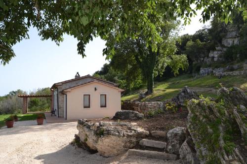 萨杜勒尼亚Il Casale delle Mura的山边的石墙小房子