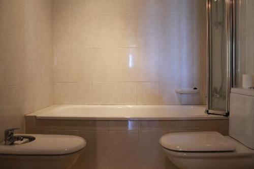 卡隆赫Villa Catalana的带淋浴、卫生间和浴缸的浴室