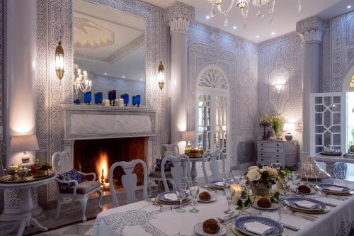 杰迪代Riad Dar El Malaika的一间带桌子和壁炉的用餐室