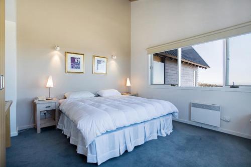 荷斯安山白色水晶公寓式酒店的白色的卧室设有一张大床和一个窗户