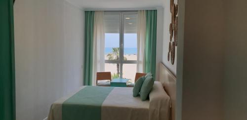 瓦伦西亚环球酒店的一间卧室设有窗户,享有海滩美景