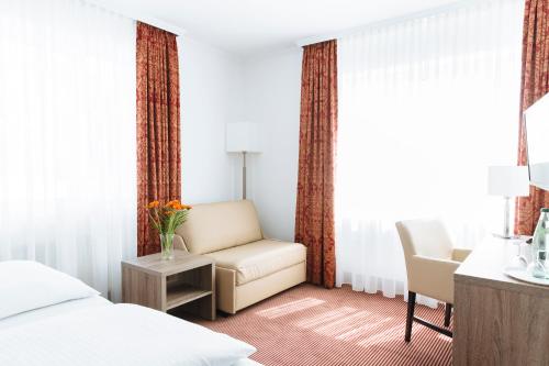 宾茨宾兹米尔宅特酒店的卧室配有床、椅子和窗户。